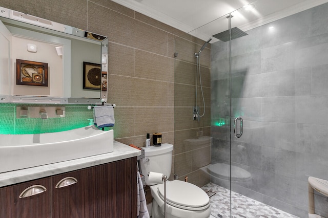 bathroom featuring toilet, an enclosed shower, ornamental molding, vanity, and tile walls