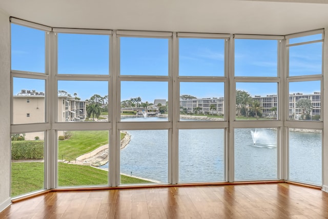 unfurnished sunroom featuring plenty of natural light and a water view