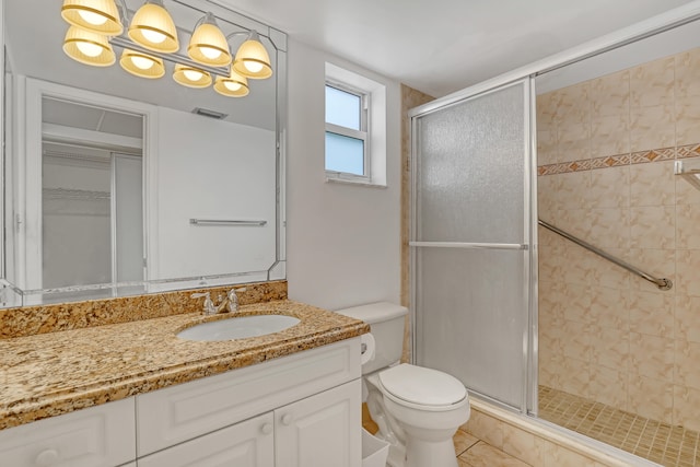 bathroom with vanity, toilet, tile patterned flooring, and a shower with door