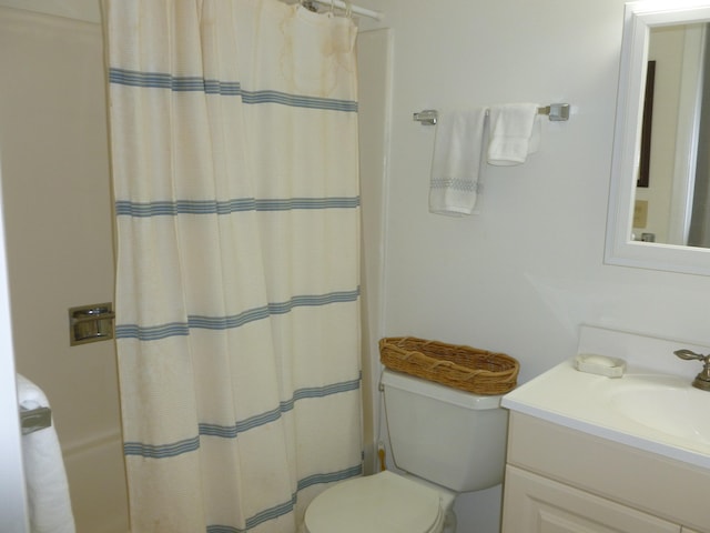 bathroom with vanity, curtained shower, and toilet