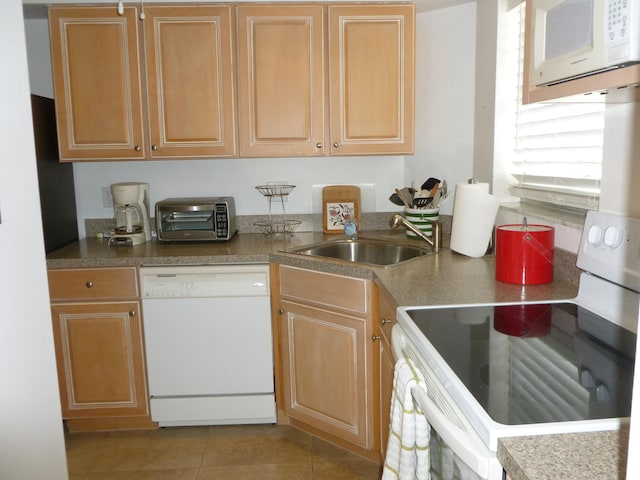 kitchen with tile patterned flooring, white appliances, and sink