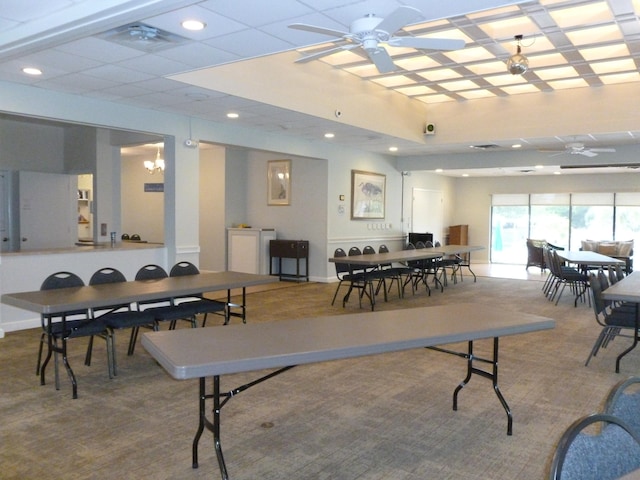 carpeted dining room featuring ceiling fan with notable chandelier