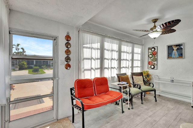 living area with plenty of natural light, ceiling fan, and light hardwood / wood-style floors