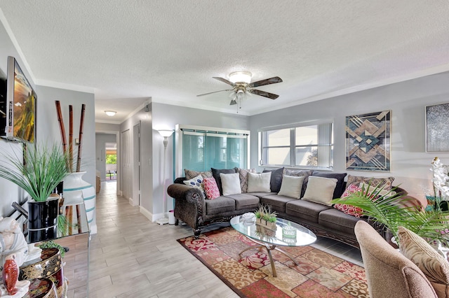 living room with a textured ceiling, crown molding, ceiling fan, and light hardwood / wood-style floors