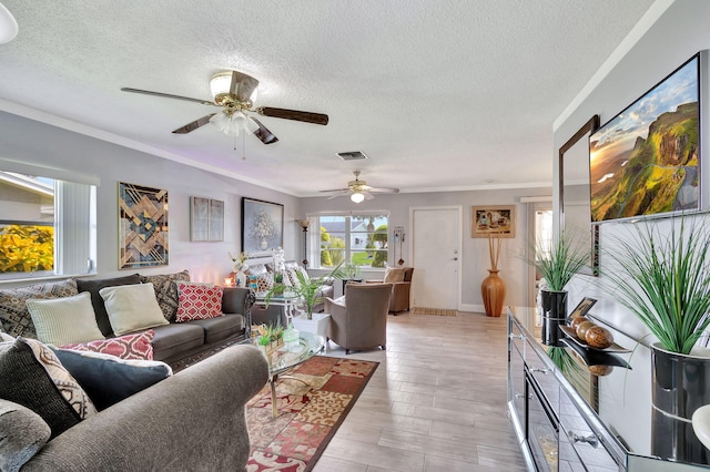 living room featuring crown molding, a textured ceiling, light hardwood / wood-style flooring, and ceiling fan