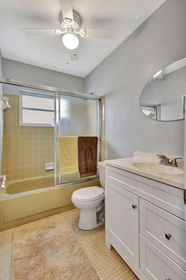 full bathroom featuring shower / bath combination with glass door, vanity, toilet, and ceiling fan