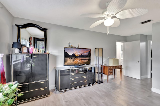 living room featuring ceiling fan and light hardwood / wood-style flooring