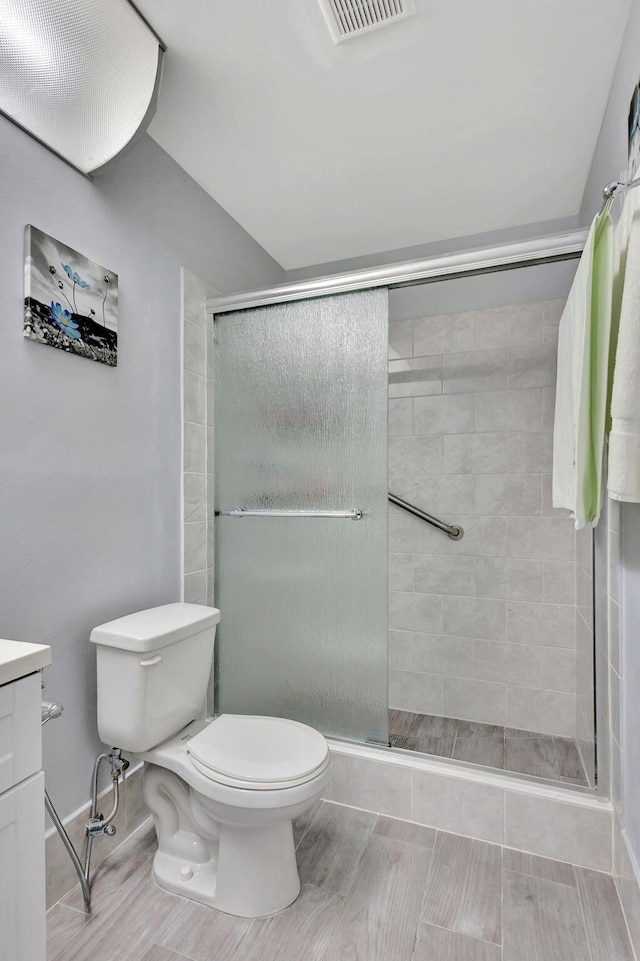 bathroom with vanity, toilet, wood-type flooring, and walk in shower