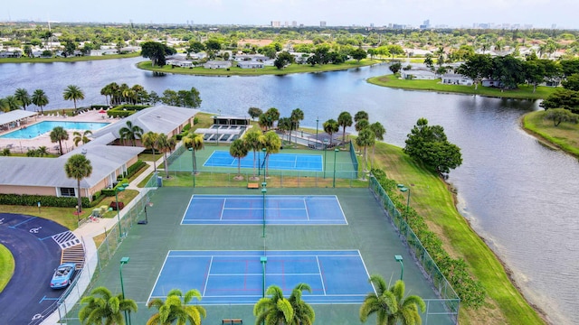 drone / aerial view of a nearby body of water and a pool