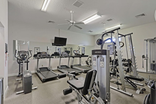 gym featuring a textured ceiling and ceiling fan