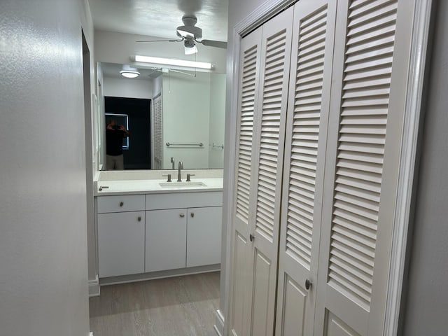 bathroom with hardwood / wood-style floors, ceiling fan, and vanity