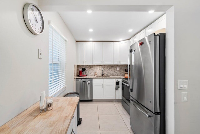 kitchen with white cabinetry, tasteful backsplash, butcher block counters, stainless steel appliances, and sink