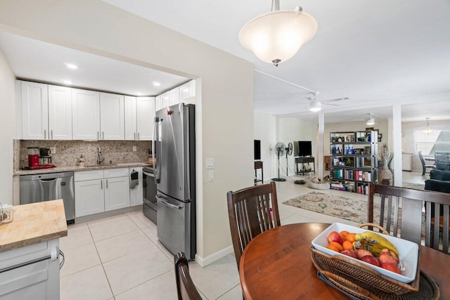 kitchen with ceiling fan, pendant lighting, sink, white cabinetry, and appliances with stainless steel finishes