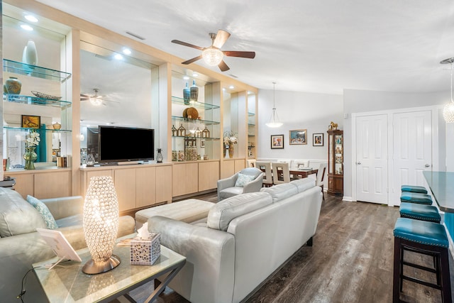 living room with ceiling fan, dark hardwood / wood-style floors, and vaulted ceiling