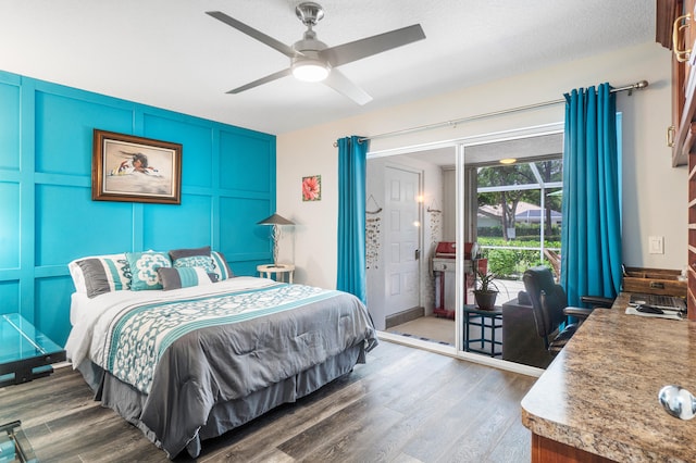 bedroom with a textured ceiling, ceiling fan, and dark hardwood / wood-style floors