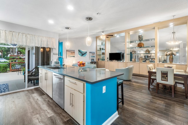 kitchen with stainless steel dishwasher, sink, dark hardwood / wood-style floors, and hanging light fixtures