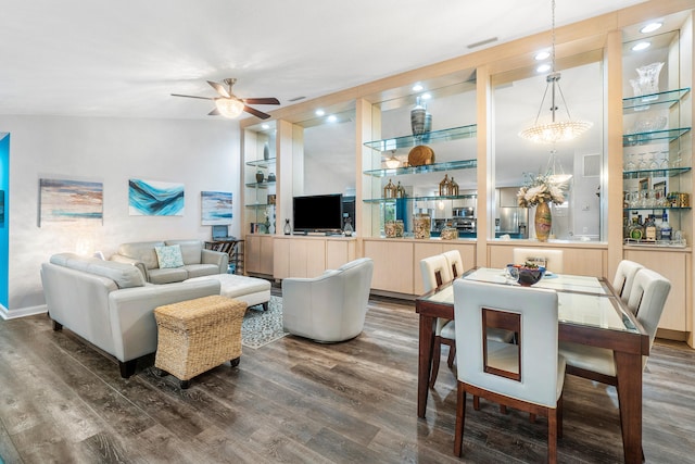 living room featuring dark hardwood / wood-style floors and ceiling fan with notable chandelier