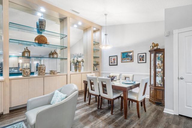 dining space featuring dark wood-type flooring and vaulted ceiling