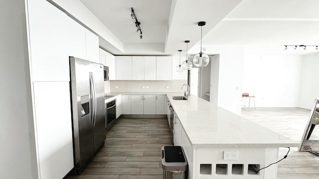 kitchen with sink, appliances with stainless steel finishes, backsplash, hanging light fixtures, and white cabinets