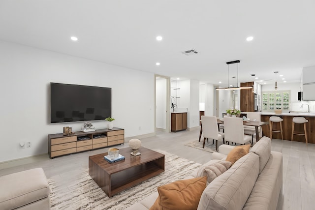 living room featuring sink and light wood-type flooring