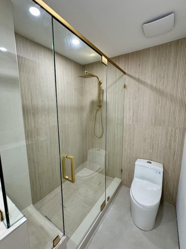 bathroom featuring a shower with shower door, tile patterned floors, and toilet