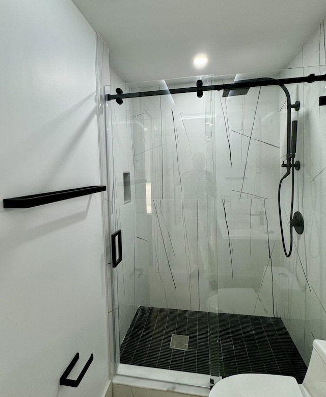 bathroom with toilet and an enclosed shower