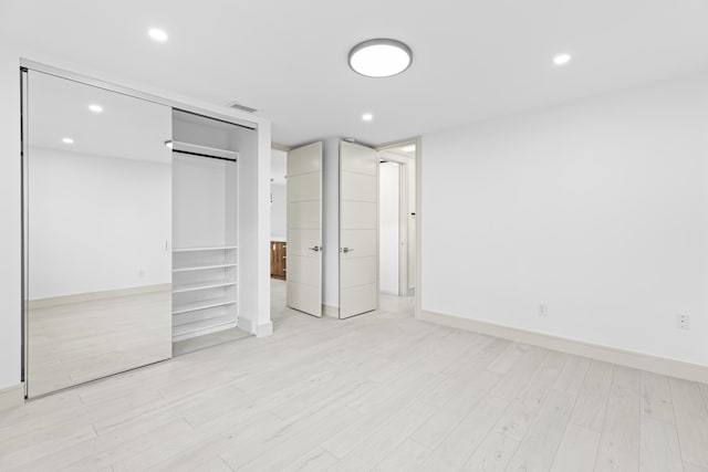 unfurnished bedroom featuring a closet and light hardwood / wood-style flooring