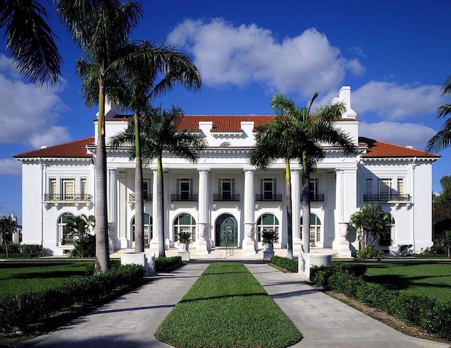 view of front of home with a balcony and a front yard