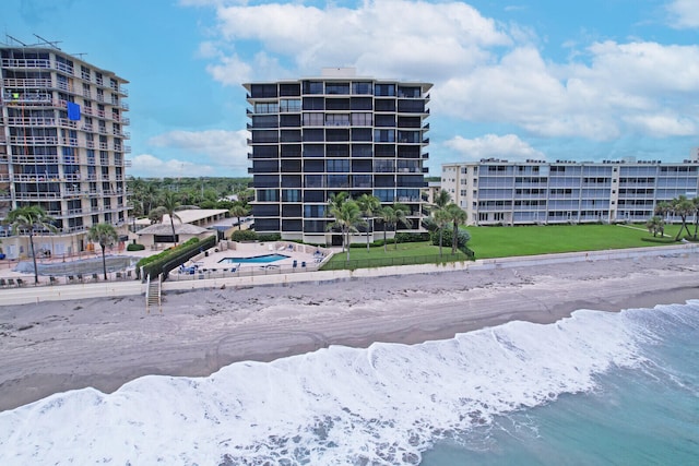 view of building exterior featuring a view of the beach and a water view