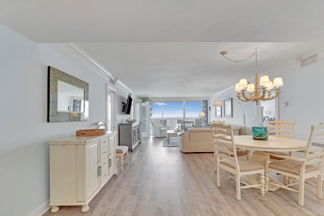 dining space featuring an inviting chandelier, light hardwood / wood-style flooring, and ornamental molding