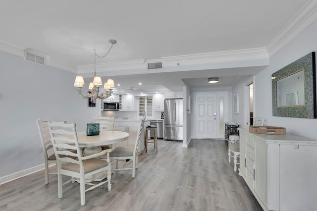 dining room featuring light hardwood / wood-style floors, ornamental molding, and an inviting chandelier