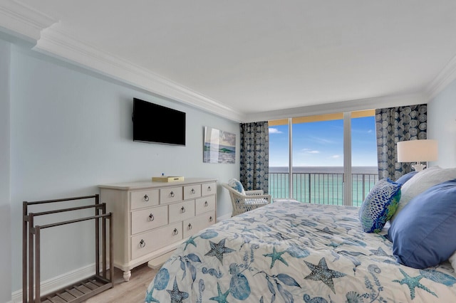 bedroom featuring light hardwood / wood-style flooring, a wall of windows, access to outside, and crown molding