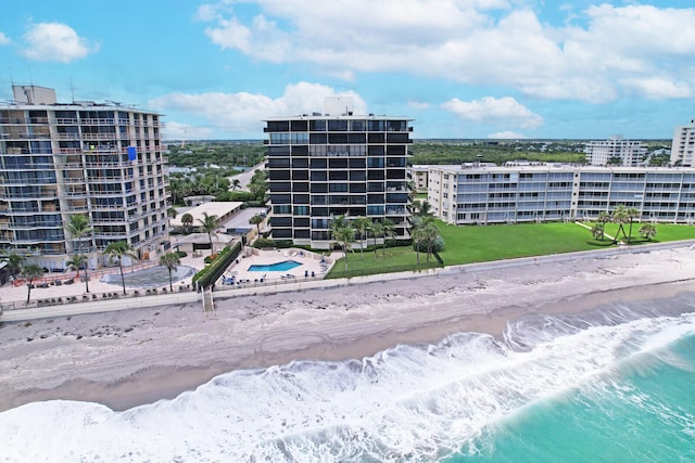 view of building exterior featuring a water view and a beach view