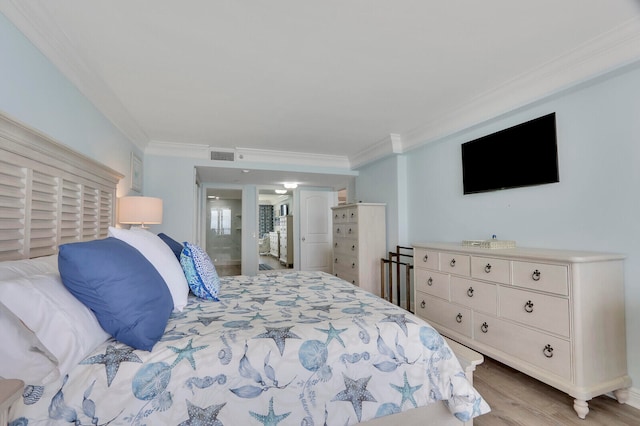 bedroom featuring light wood-type flooring and crown molding