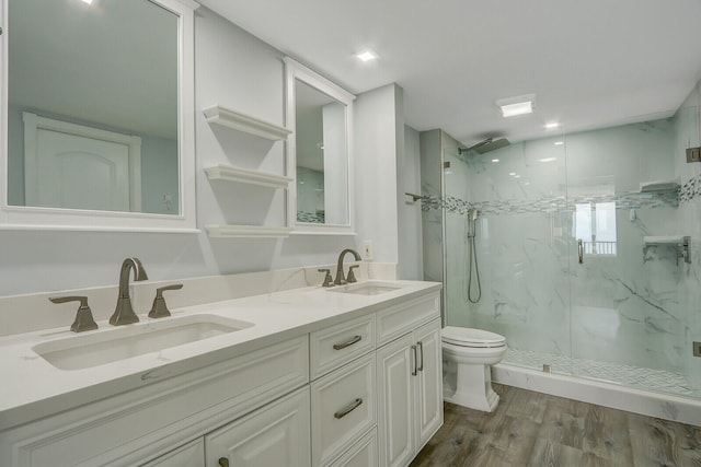 bathroom with hardwood / wood-style floors, vanity, a shower with shower door, and toilet