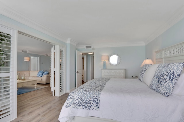 bedroom featuring ornamental molding and light hardwood / wood-style flooring