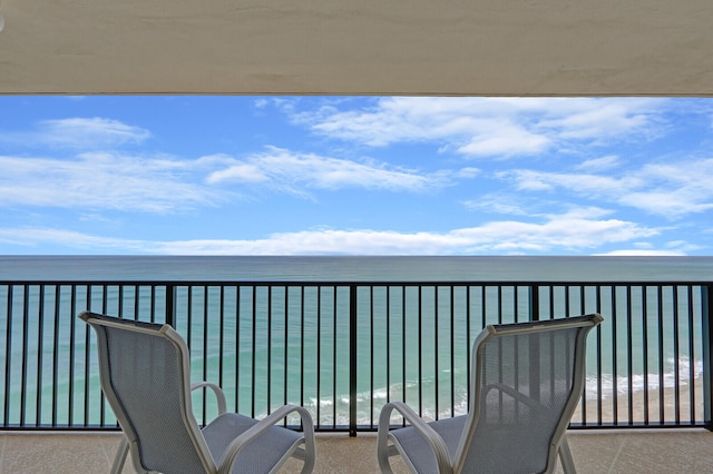 balcony with a water view and a beach view