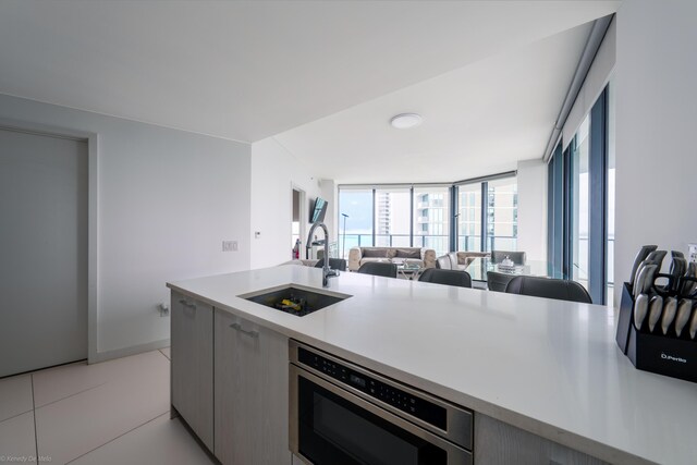 kitchen featuring oven, sink, and light tile patterned flooring