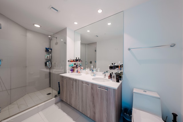 bathroom featuring vanity, a tile shower, and tile patterned flooring