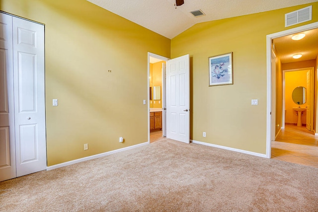 unfurnished bedroom featuring lofted ceiling and light colored carpet