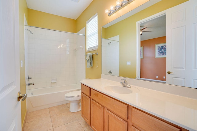 full bathroom featuring tiled shower / bath, tile patterned floors, toilet, ceiling fan, and vanity