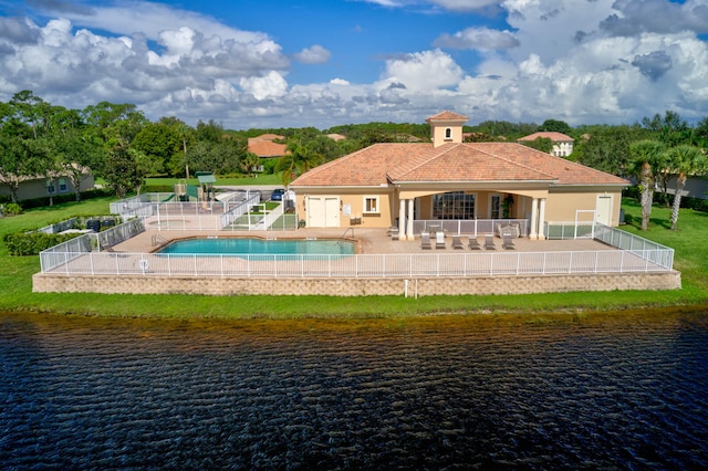 rear view of house with a patio area, a yard, and a water view