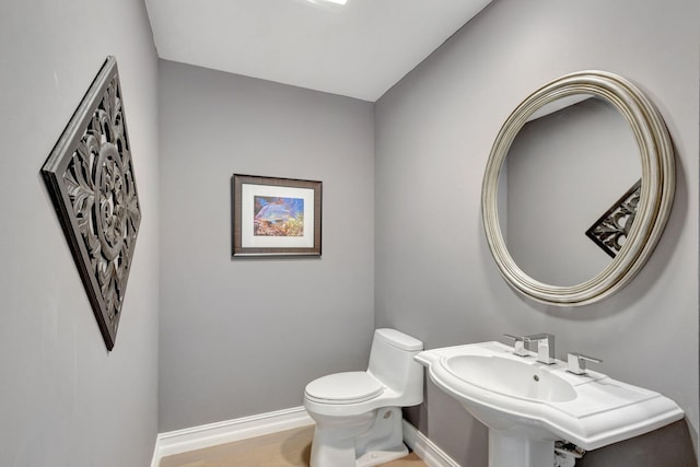 bathroom with toilet and wood-type flooring