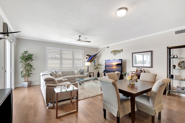 dining room with ornamental molding, light hardwood / wood-style flooring, and plenty of natural light