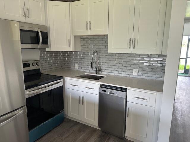 kitchen featuring sink, tasteful backsplash, white cabinetry, stainless steel appliances, and dark hardwood / wood-style flooring