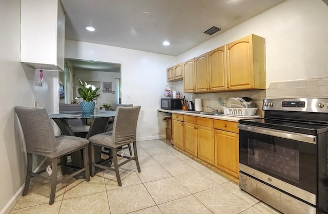 kitchen featuring light tile patterned flooring, stainless steel electric range oven, sink, and tasteful backsplash