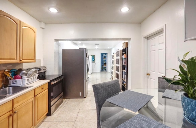 kitchen with light tile patterned flooring, stainless steel appliances, and sink