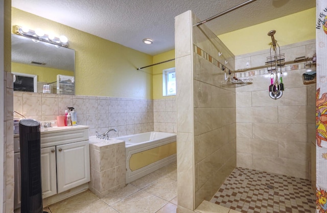 bathroom with tile walls, vanity, a textured ceiling, independent shower and bath, and tile patterned floors