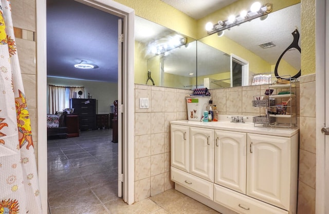 bathroom with tile walls, tile patterned flooring, and vanity