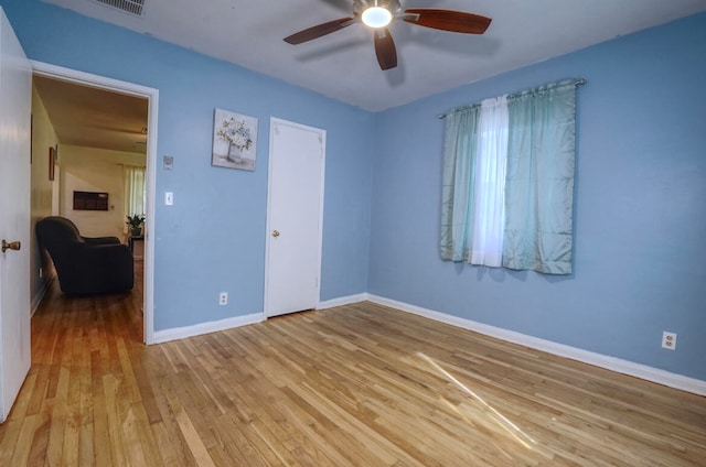 empty room featuring light wood-type flooring and ceiling fan